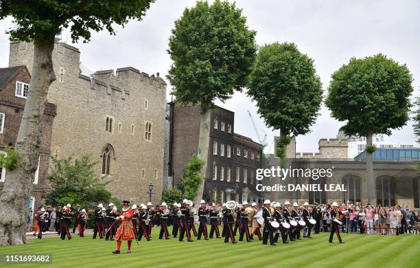 Members of the Royal Marines Corps of Drums perform, led by a Yeomen Warder, as they march through the Tower of London in central London on June 24,...