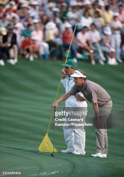 Scottish golfer Sandy Lyle lines up a putt with his caddy, Dave Musgrove, on the last hole enroute to winning the US Masters Golf Tournament at the...