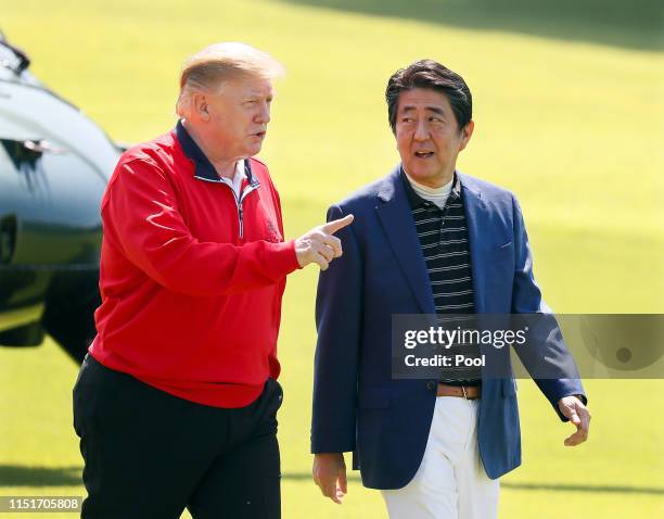 President Donald Trump and Japanese Prime Minister Shinzo Abe talk on the way to play golf at Mobara Country Club on May 26, 2019 in Chiba, Japan....