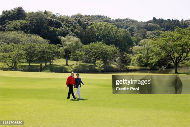 President Donald Trump and Japanese Prime Minister Shinzo Abe talk on the way to play golf at Mobara Country Club on May 26, 2019 in Chiba, Japan....