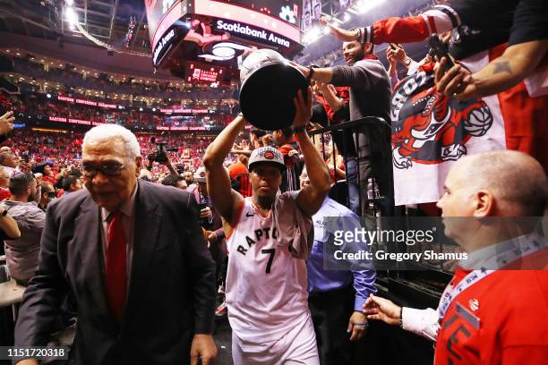 Kyle Lowry of the Toronto Raptors walks off the court with the Eastern Conference Finals trophy after defeating the Milwaukee Bucks 100-94 in game...