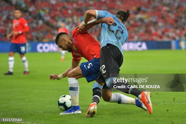 Chile's Paulo Diaz and Uruguay's Martin Caceres vie for the ball during their Copa America football tournament group match at Maracana Stadium in Rio...