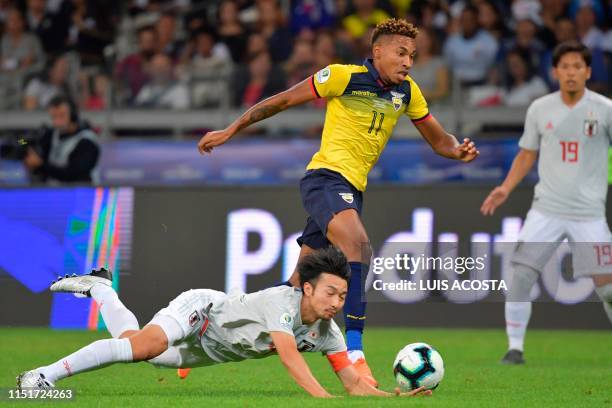 Japan's Gaku Shibasaki falls next to Ecuador's Ayrton Preciado during their Copa America football tournament group match at the Mineirao Stadium in...