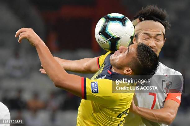 Ecuador's Andres Chicaiza and Japan's Gaku Shibasaki vie for the ball during their Copa America football tournament group match at the Mineirao...