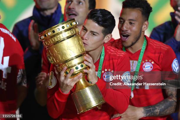 James Rodriquez of Bayern Muenchen lifts the trophy in celebration with team mates after the DFB Cup final between RB Leipzig and Bayern Muenchen at...