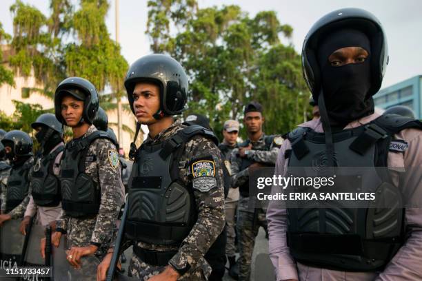 NAtional Police members stand guard as supporters of former Dominican President Leonel Fernandez hold a protest outside the National Congress,...