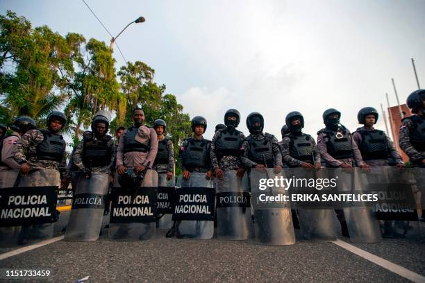 NAtional Police members stand guard as supporters of former Dominican President Leonel Fernandez hold a protest outside the National Congress,...