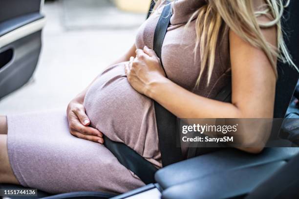 schwangere frau mit sicherheitsgurt - pregnant woman car stock-fotos und bilder
