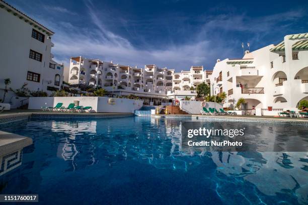 Swimming pool during the day and night at a luxury all-inclusive holidays hotel with view of the ocean at Callao Salvaje, in Tenerife island, Canary...