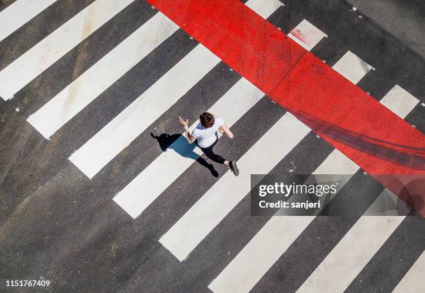 woman running through a zebra crossing - crossing imagens e fotografias de stock