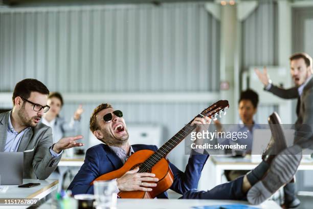 stop playing that guitar, we cannot work! - annoying colleague stock pictures, royalty-free photos & images