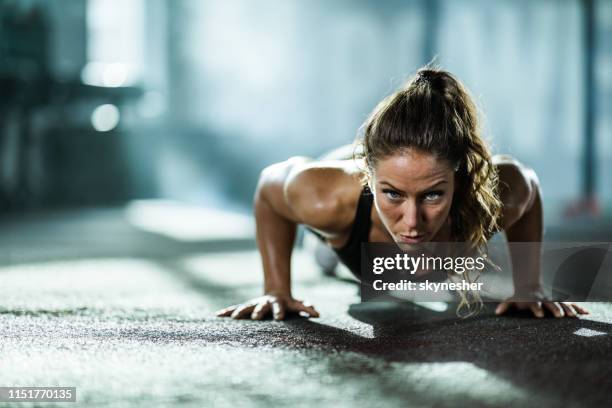 athletic woman exercising push-ups in a health club. - woman press ups stock pictures, royalty-free photos & images