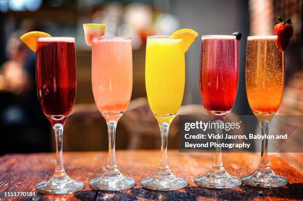 assortment of colorful brunch cocktails, including mimosas and other fruit concoctions - mimosa foto e immagini stock