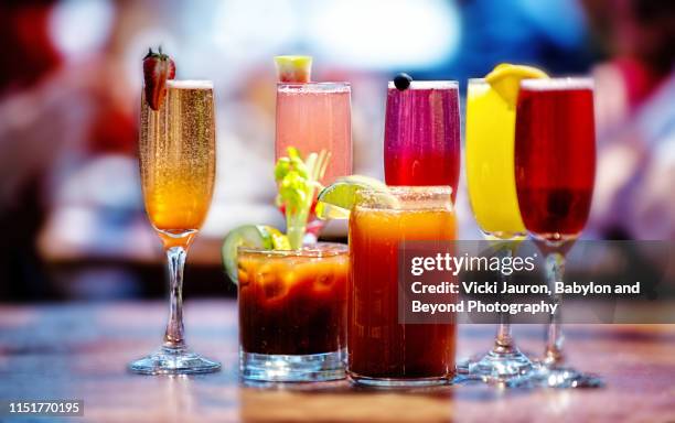 assortment of brunch cocktails, including bloody mary and mimosas - colorful vegetables summer stock-fotos und bilder