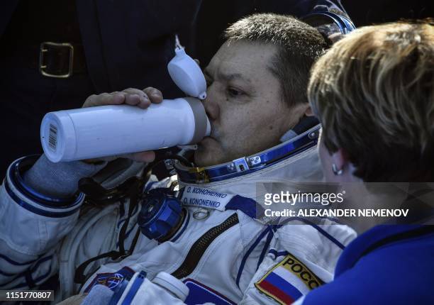 Russian cosmonaut Oleg Kononenko drinks shortly after landing in a remote area outside the town of Dzhezkazgan , Kazakhstan, on June 25, 2019. - The...