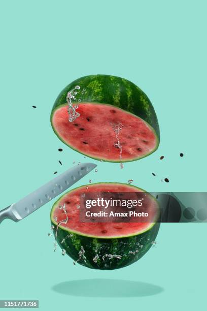 mit messer geschnittene wassermelone fliegen mit spritzer auf pastellgrünem hintergrund. minimales obst-und sommerkonzept. - knife splash stock-fotos und bilder