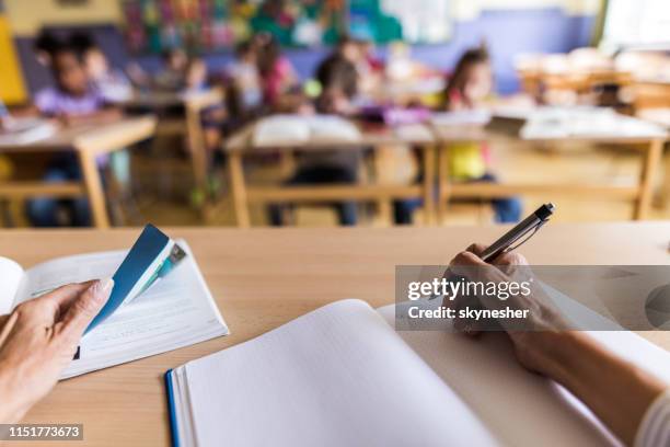 primo livello di insegnante irriconoscibile che prende appunti su una classe. - teacher desk foto e immagini stock