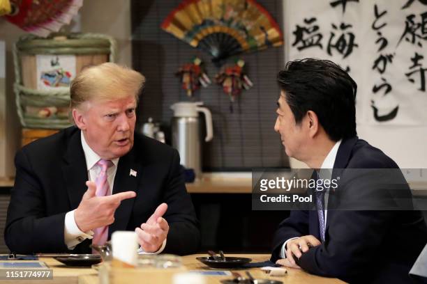 President Donald Trump, left, speaks with Shinzo Abe, Japan's Prime Minister, while sitting at a counter during a dinner at the Inakaya restaurant in...
