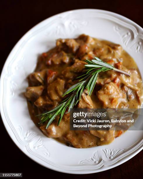 homemade veal stew in spicy cream sauce with tarragon garnish - dragon stockfoto's en -beelden