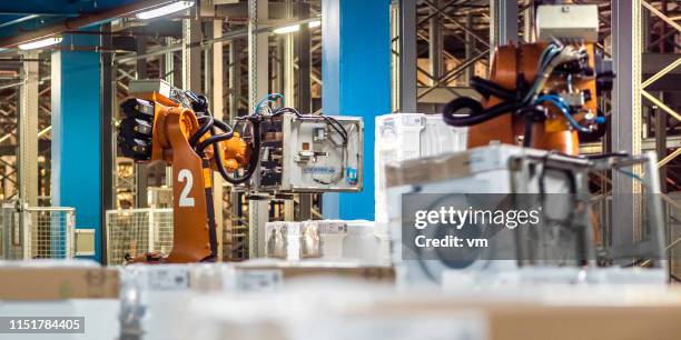 robotic arm moving washing machine in a factory - appliance manufacturing stock pictures, royalty-free photos & images