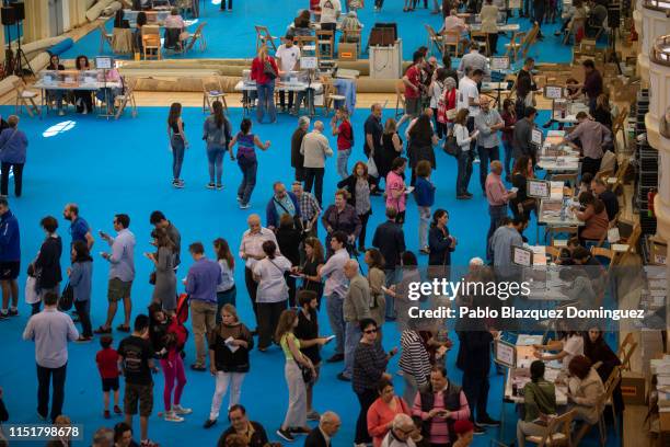 People queue to cast their ballots at a polling station during voting for the Spanish local, regional and European parliamentary elections on May 26,...