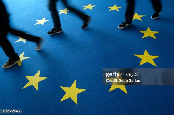 People walk across carpeting with the flag of the European Union at the headquarters of the German Christian Democrats during European parliamentary...