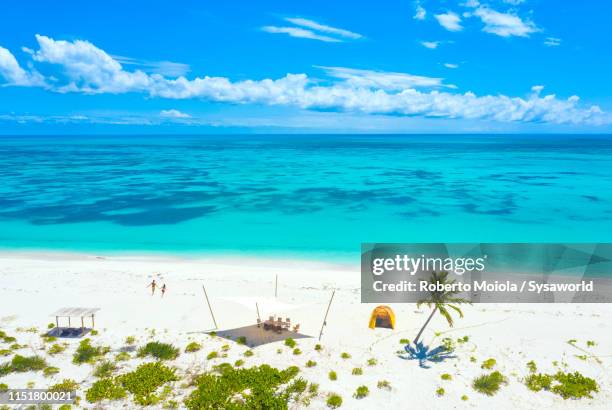 aerial view of man and woman on pink sand beach, caribbean - bahamas aerial stockfoto's en -beelden