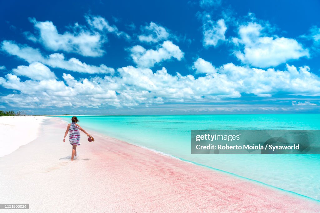 Woman walking through shallow crystal water, Caribbean