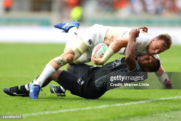 Ben Pinkelman of the USA is tackled by Paula Dranisinukula of Fiji during the Cup Semi FInal match on day two of the HSBC London Sevens at Twickenham...