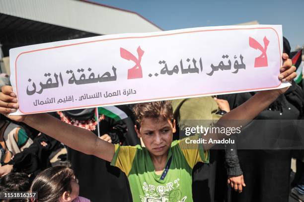 Child holds a banner during a protest against the U.S.-led conference in Bahrain on June 25, 2019 in Beit Lahia, Gaza. U.S. Officials are expected to...