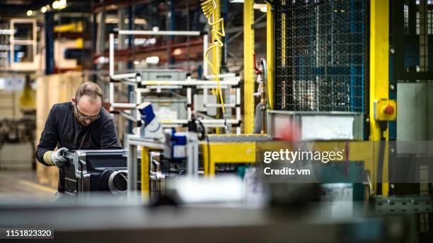 man assembling a washing machine in a factory - appliance manufacturing stock pictures, royalty-free photos & images