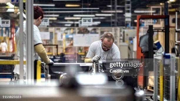 two production line workers assembling home appliances - appliance manufacturing stock pictures, royalty-free photos & images