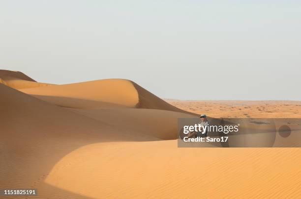 lonely man at wahiba sands, oman. - oman muscat stock pictures, royalty-free photos & images