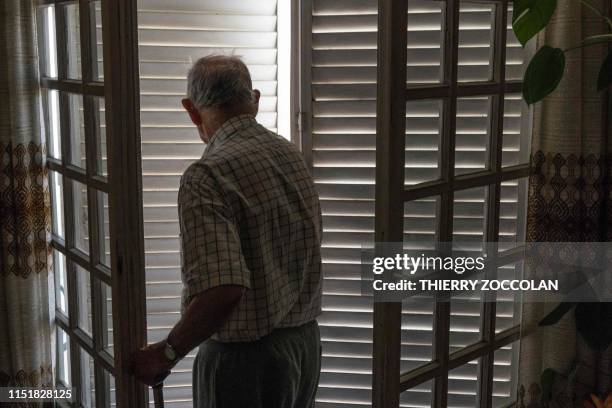 An elderly person closes his shutters to keep cool and to avoid heatstroke during the heatwave on June 25, 2019 in Clermont-Ferrand. Forecasters say...