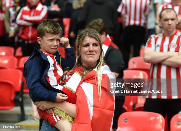 Young Sunderland fan and his guardian look dejected following their team's defeat in the Sky Bet League One Play-off Final match between Charlton...