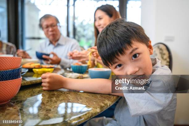 taiwanesischer junge genießt mittagessen mit mutter und großvater - verschiedene kulturen stock-fotos und bilder