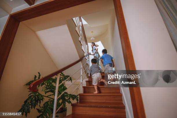 taiwanese moeder en jonge zonen oplopende trap - tree area stockfoto's en -beelden