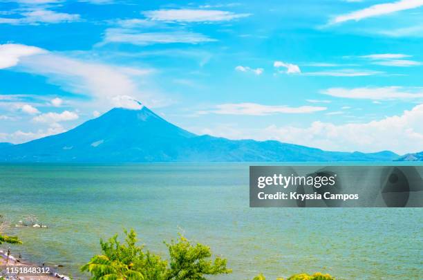 volcano rises beside lake managua (xolotlán) in nicaragua - managua stock pictures, royalty-free photos & images