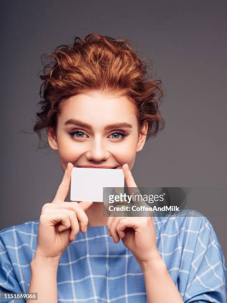 young woman holding a business card - showing id stock pictures, royalty-free photos & images