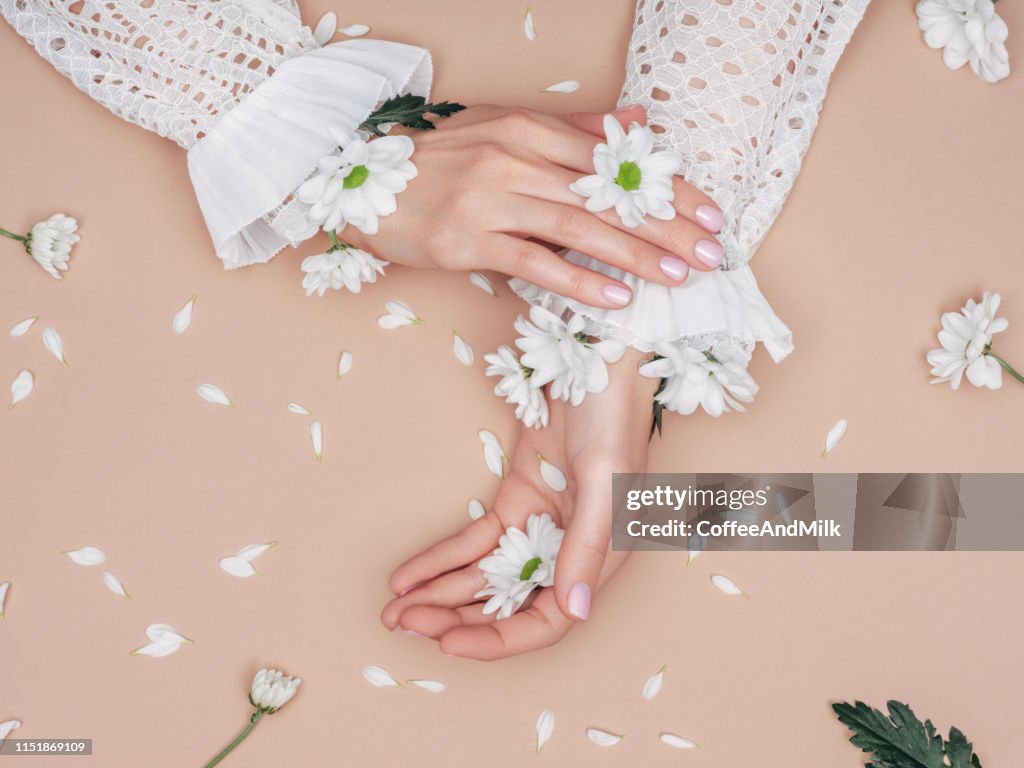 Foto van de handen en de bloemen van de mooie vrouw