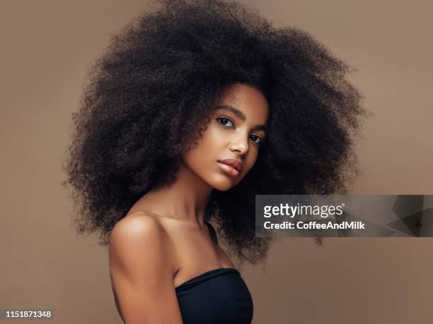 schöne lächelnde mädchen mit lockigen frisur - afro hairstyle stock-fotos und bilder