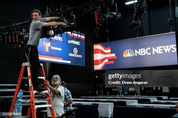 Workers assemble the television set inside the media filing center at Adrienne Arsht Center for the Performing Arts where the first Democratic...