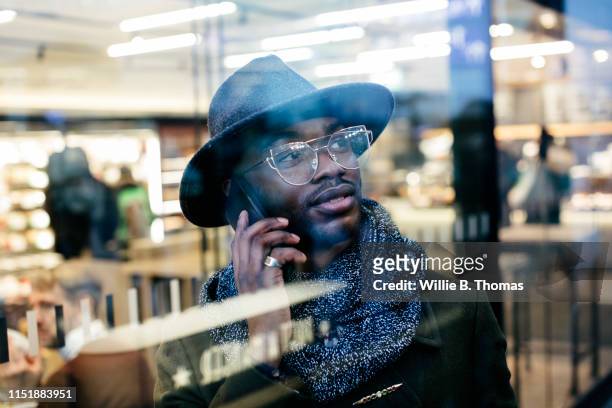 Portrait of confident businessman on cell phone behind windowpane