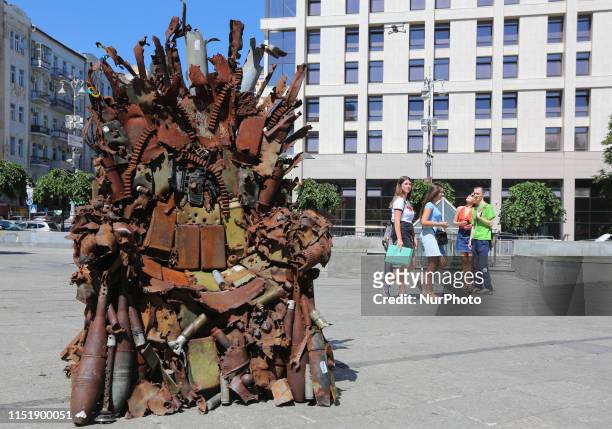 People walk past the iron Throne installed at Independence Square in Kyiv, Ukraine, June 25, 2019. &quot;The Iron Throne of the East&quot; made by...