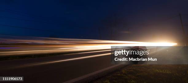 light trails from cars moving on a road - road light trail stock pictures, royalty-free photos & images