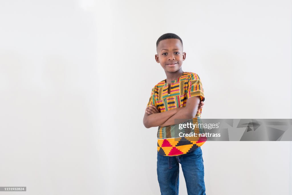 Retrato de largo medio de niño sonriente con los brazos cruzados