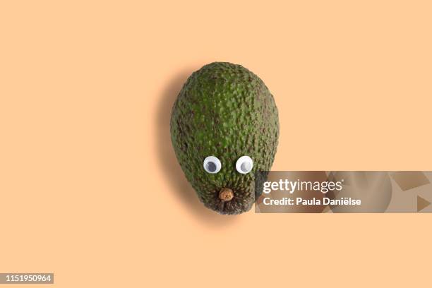 green avocado with googly eyes - avocado isolated stock-fotos und bilder