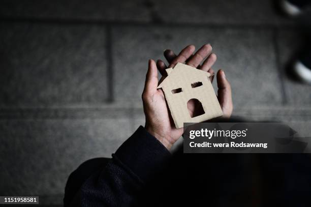 hands of homelessness poor man holding  the paper house - exile photos et images de collection