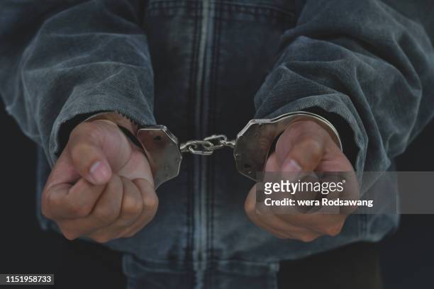 handcuffed man - armed robbery stock pictures, royalty-free photos & images