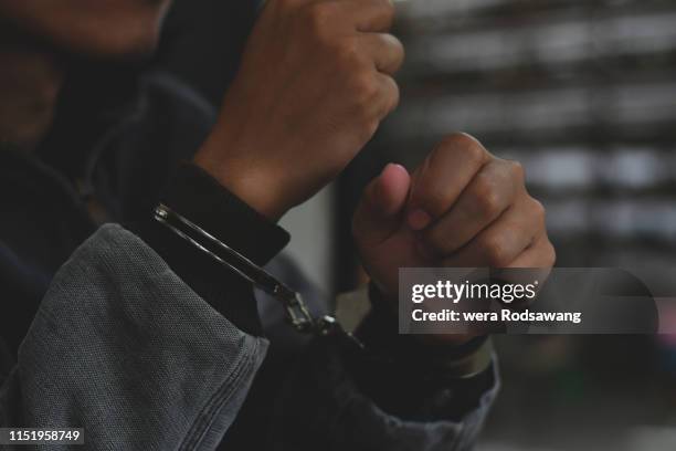 handcuffed man - bank robber stock pictures, royalty-free photos & images